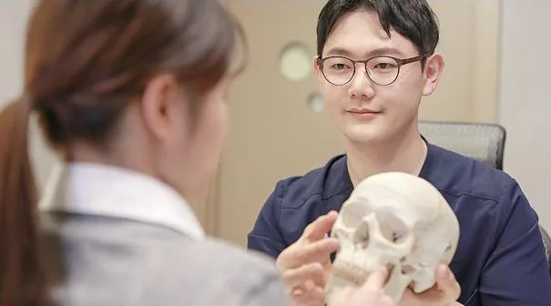 Dr. Chang Min Kang explaining cheekbone anatomy using a skull model